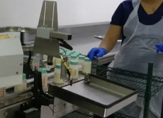 Donated milk bottles moving through The Milk Bank's processing line