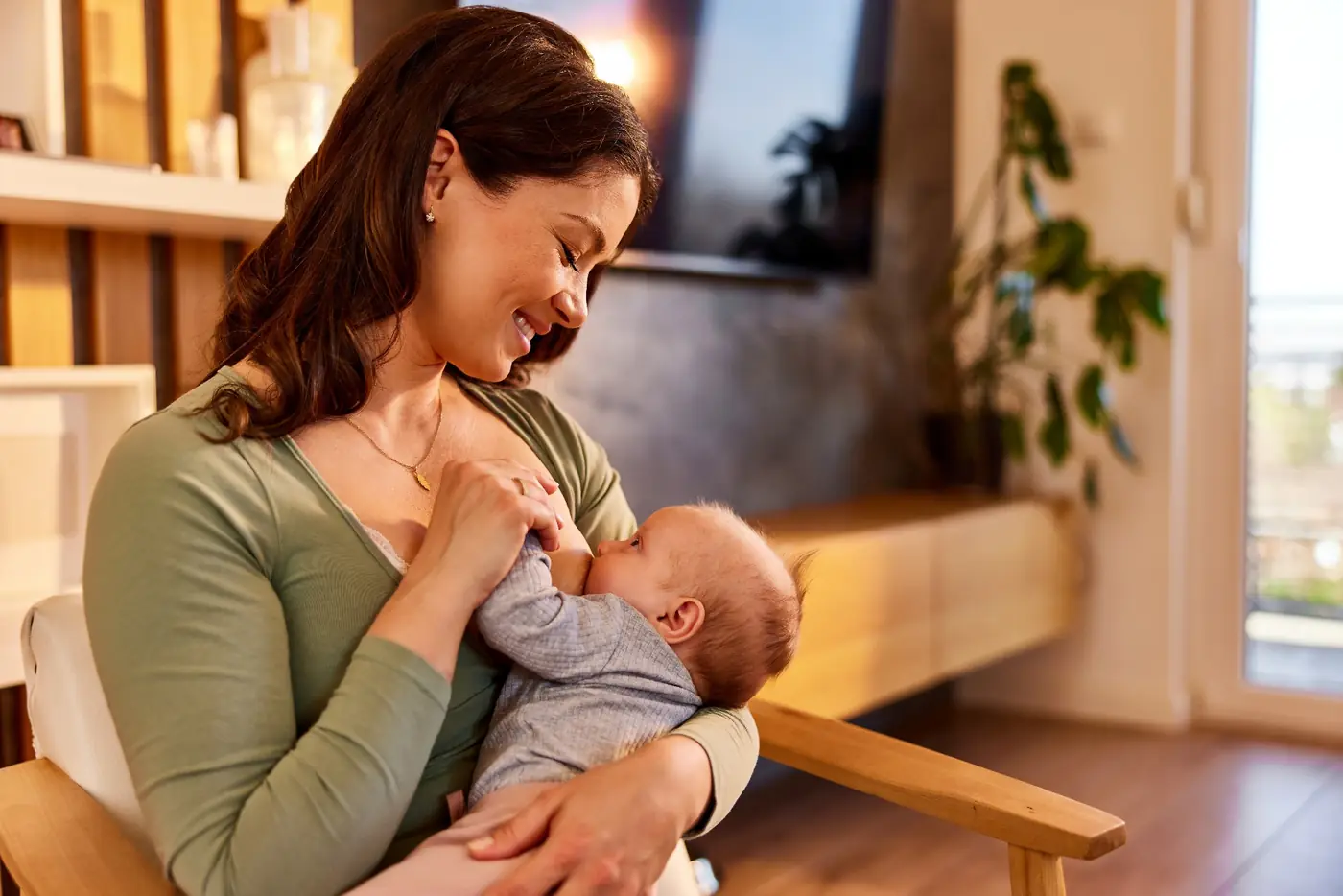 A mother holding her infant in a bright home