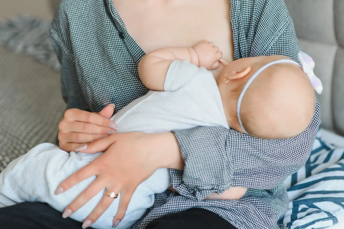 An infant nursing in a parent's arms